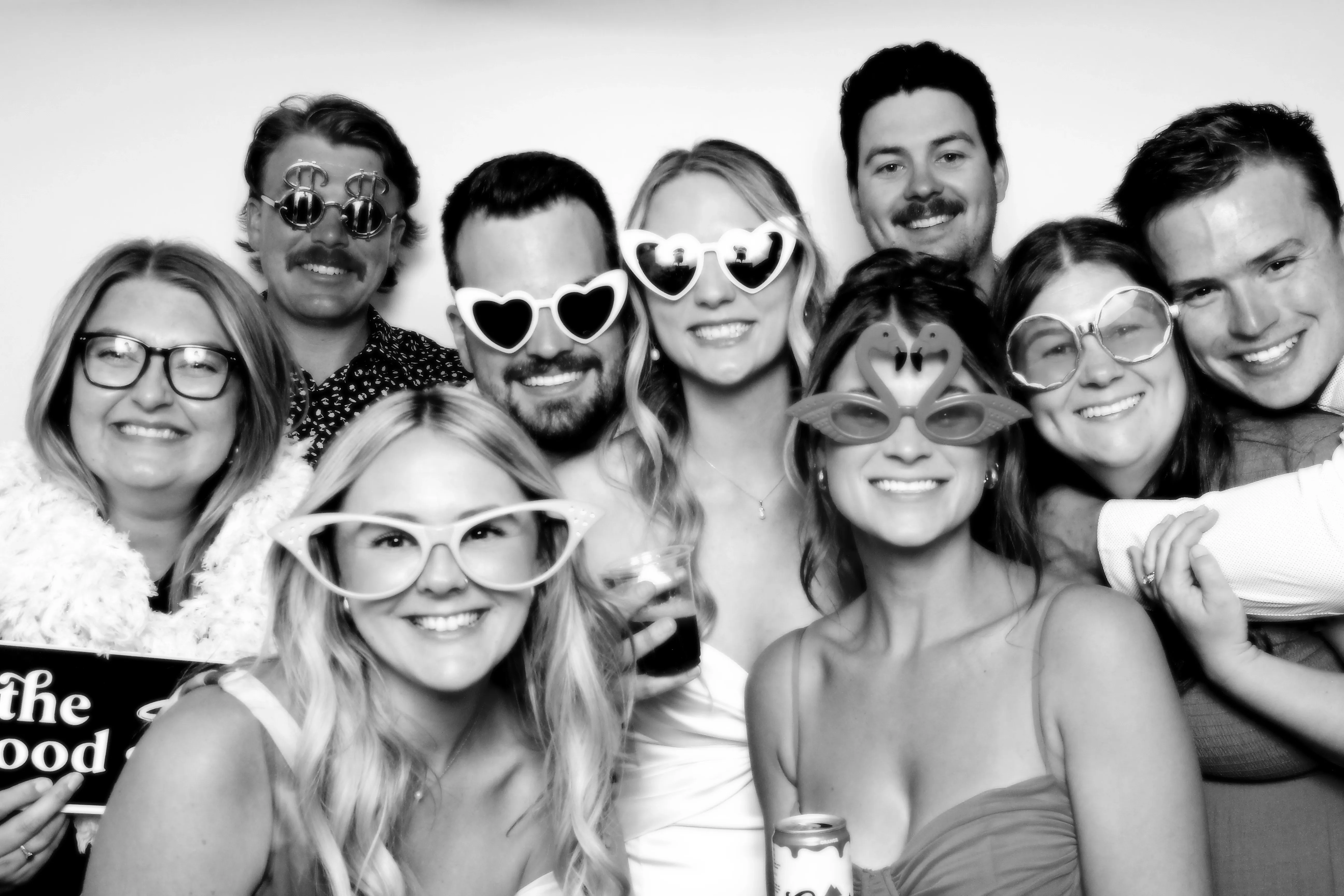 A fun group of friends striking poses with oversized fun props, black and white